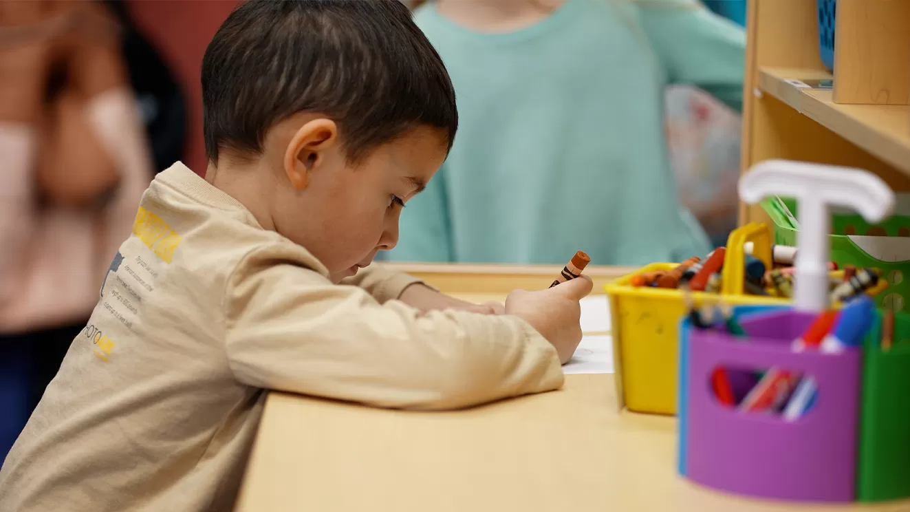 young boy coloring withy a crayon