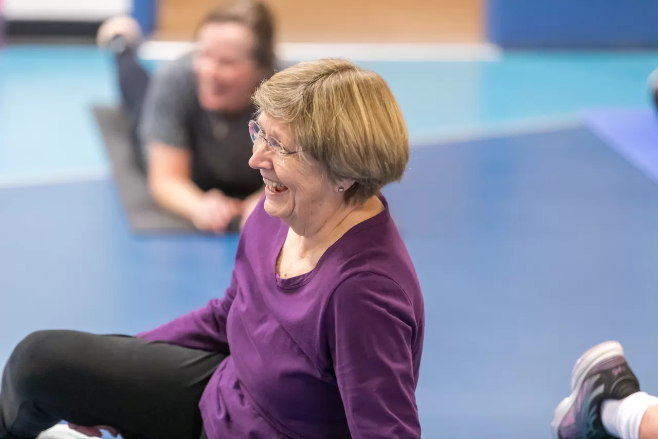 Senior woman laughing in a group exercise class