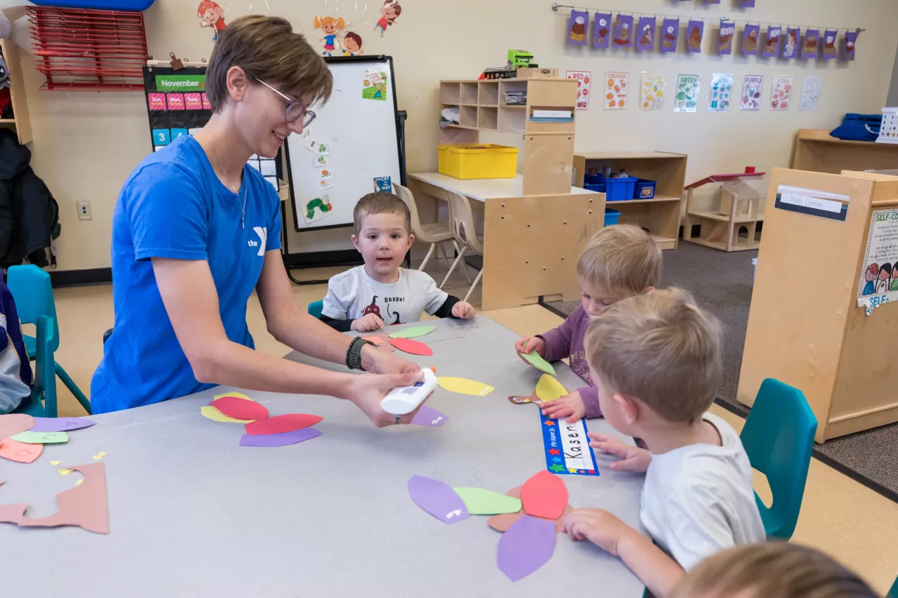 YMCA leader and children making crafts