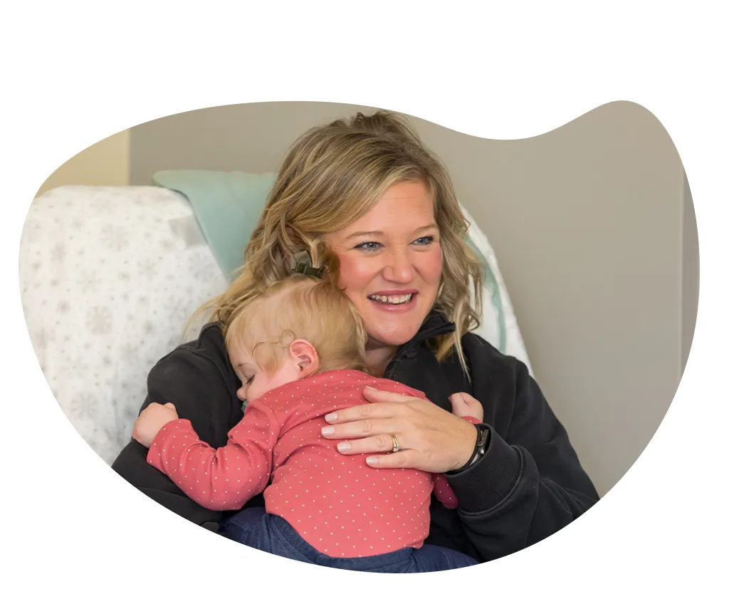 YMCA leader holding a sleeping infant