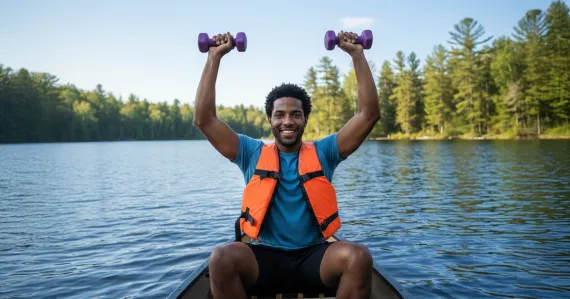 man in a canoe holding up dumbbells