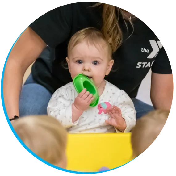 child playing in a sandbox in a YMCA classroom