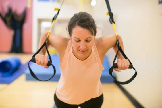 woman doing a TRX workout in the YMCA gymnasium