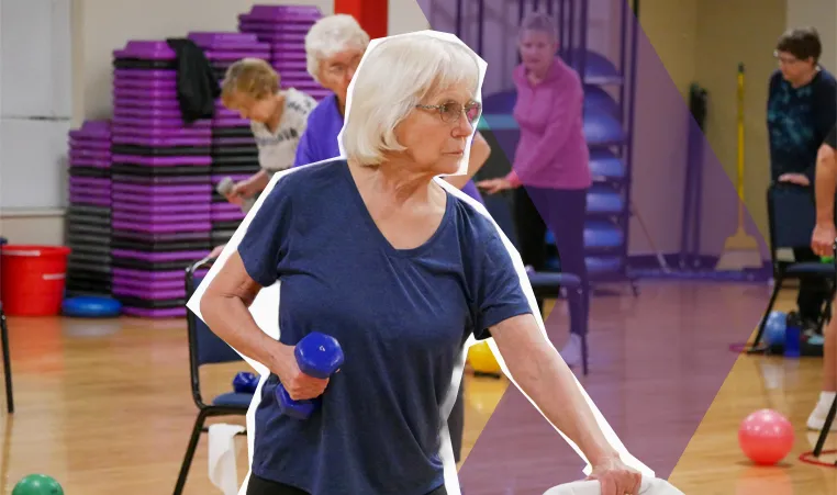 senior woman lifting dumbbells in a group class