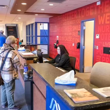 woman checking in at a gym's front desk