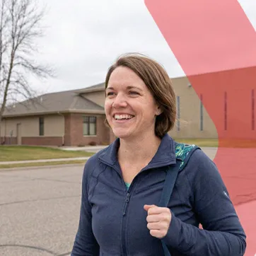 woman walking outside with a gym bag