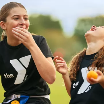 2 girls eating oranges and laughing