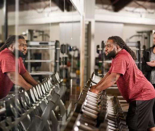 man putting dumbbells on dumbbell rack
