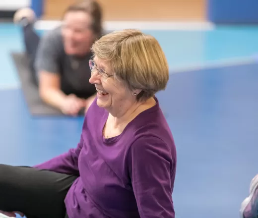 Senior woman laughing in a group exercise class