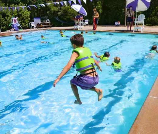 Child jumping into swimming pool